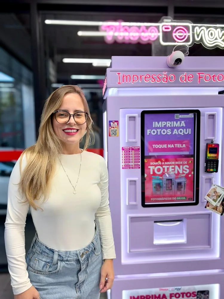 Camila Steinmetz ao lado do totem Photo Now em Tramandaí